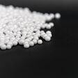 White Polystyrene foam beads on black background with copy space, waste cushioning material in luxury packaging