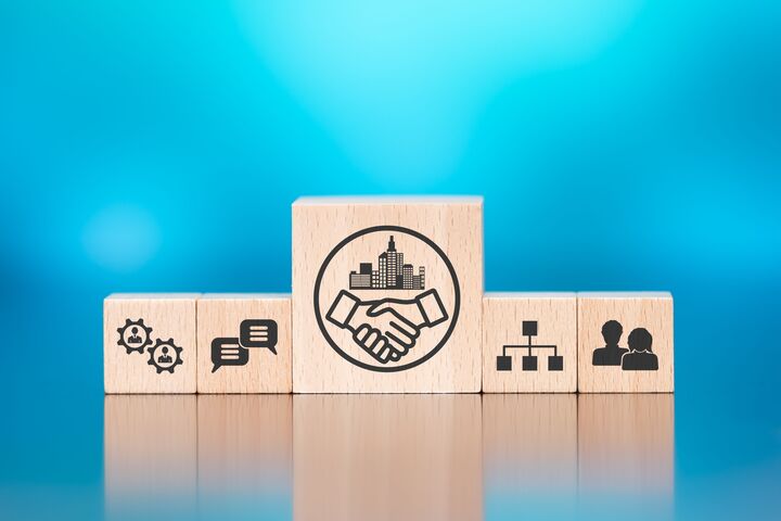 Wooden blocks with symbol of business relationship concept on blue background