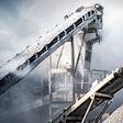 Cement production factory on mining quarry. Conveyor belt of heavy machinery loads stones and gravel