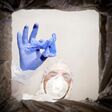 a man in a protective suit throws used medical glove into a trash can. Bottom view from the trash can. The problem of recycling and pollution of the planet with garbage.