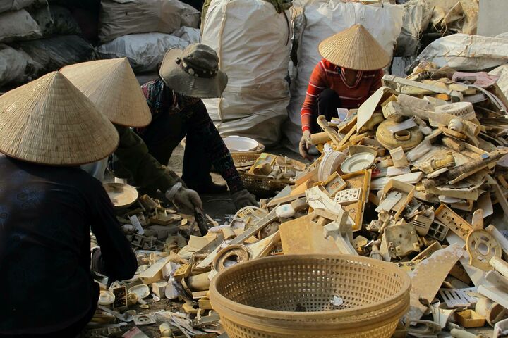 Vietnamese women sorting non-hazardous electronics and appliance waste.