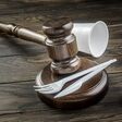 Gavel and white plastic items on table. Single use plastics ban concept