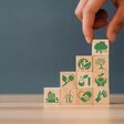 Hand puts the wooden cubes with CO2 emission reduction icon. CO2 emission concept. Green industries business concept.
