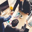 Group business people handshake at meeting table in office together with confident shot from top view . Young businessman and businesswoman workers express agreement of investment deal.