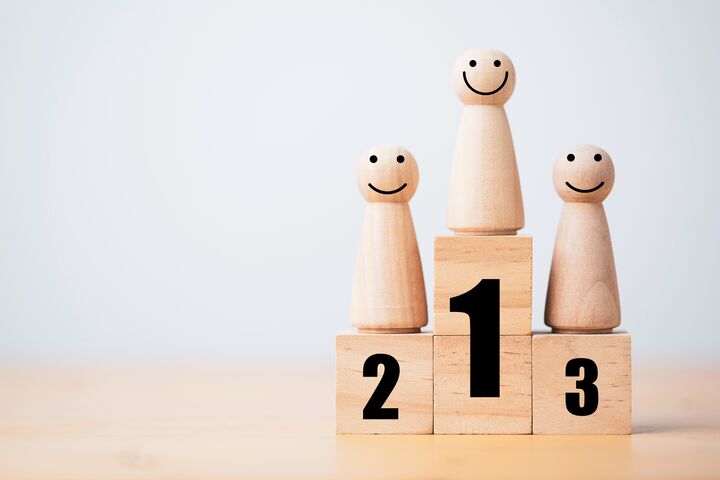Wooden human standing on podium with ranking for winner business and sport competition concept.