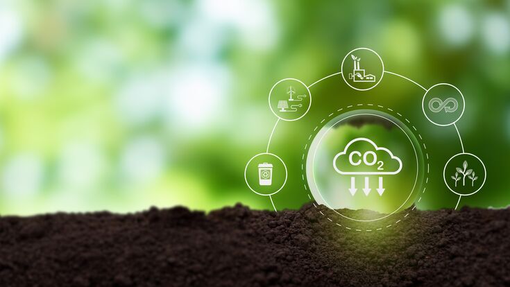 Reducción de las emisiones de carbono, concepto de carbono neutral. Objetivo de cero emisiones netas de gases de efecto invernadero. Concepto de reducción de la huella de carbono. Disminución del símbolo de objetivo de emisiones de CO2 en el fondo de la vista verde.