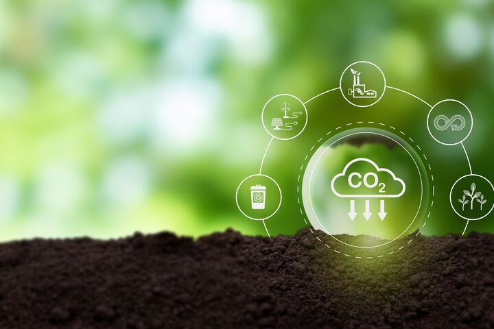 Reduction of carbon emissions, carbon neutral concept. Net zero greenhouse gas emissions target. Reducing carbon footprint concept. Decreasing CO2 emissions target symbol on green view background.