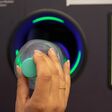 Junge Frau wirft leere Plastik Pflandflaschen in Automat. Automatisierte Leergutrücknahme