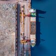 Waste loading at port cargo ship transports of garbage for recycling factory. Concept plastic Pollution environment, aerial top view.