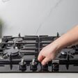 A man turns on the gas on the hob in a modern kitchen. Gas stove safety, gas control and safety shutdown.