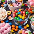 Variety of milk chocolate and jelly sugar gum sweets and candies on black. Best snacks for kids parties.