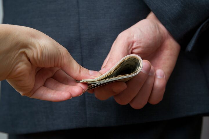 Concept - corruption. Giving a bribe. Money in hand