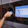 25 July 2022, Munster, Germany: A student girl hands over a plastic beverage bottle for recycling to automated machine. Eco friendly lifestyle and cashback