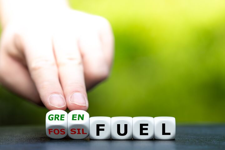 Hand turns dice and changes the expression "fossil fuel" to "green fuel".