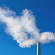 two smoking chimneys on blue sky background