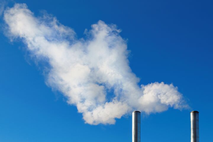 two smoking chimneys on blue sky background