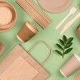 Eco-friendly tableware - kraft paper food packaging on light green background. Street food paper packaging, recyclable paperware, zero waste packaging concept. Flat lay