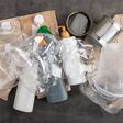 Recycling and ecology concept. Sorting household waste captured from above, flat lay. Grey concrete background
