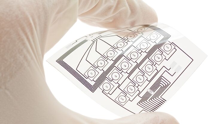 Técnico sosteniendo un diseño de circuito eléctrico flexible