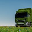 Eco friendly transportation concept. 3d rendering of a green truck on fresh spring meadow with blue sky in background - 3D Illustration