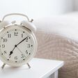 retro white alarm clock on white table in the bedroom