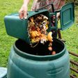 A woman emptying a home composting bin into an outdoor compost bin to reduce waste