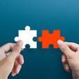 Businessman hands connecting puzzle pieces representing the merging of two companies or joint venture, partnership, Mergers and acquisition concept