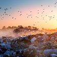 beautiful foggy dawn of the Sun over a huge field of urban garbage, saturated with poisonous fumes of decomposition of organic waste and household chemicals