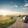 car for traveling with a mountain road. Blue sky