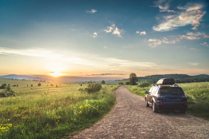 car for traveling with a mountain road. Blue sky