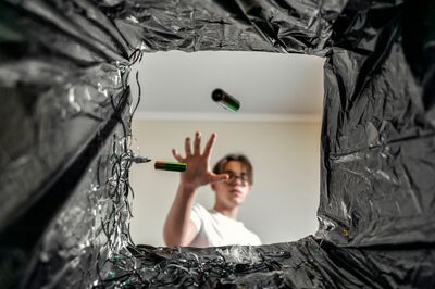 © Елена Гурова - stock.adobe.com man throws batteries in the trash. battery recycling. view from the trash can