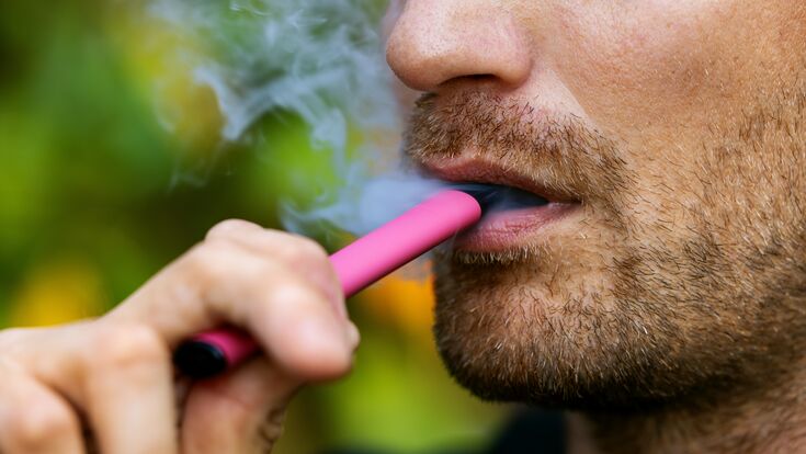 © ronstik - stock.adobe.com man smoking disposable electronic cigarette. face closeup