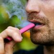 man smoking disposable electronic cigarette. face closeup
