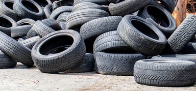 Industrial dump for the processing of used tires and rubber tires. Pile of old tires and wheels for rubber recycling. Tire dump. Recycling of used tires. Produced reclaimed tire rubber