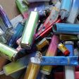 Discarded electronic cigarette vapes that have been collected from roads and pavements shot over a pale cardboard background