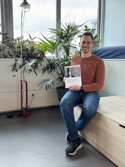 Author Florian Würrer with the Climate Lab report on the recovery of critical raw materials from electronic waste.